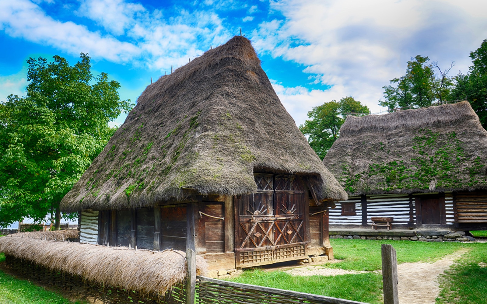 Traditional Romanian village house with thatched roof at Dimitrie Gusti National Village Museum.