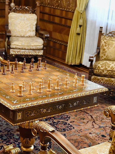 Chess set on ornate table in Ceausescu Mansion's opulent room, part of Fast Track Guided Tour.