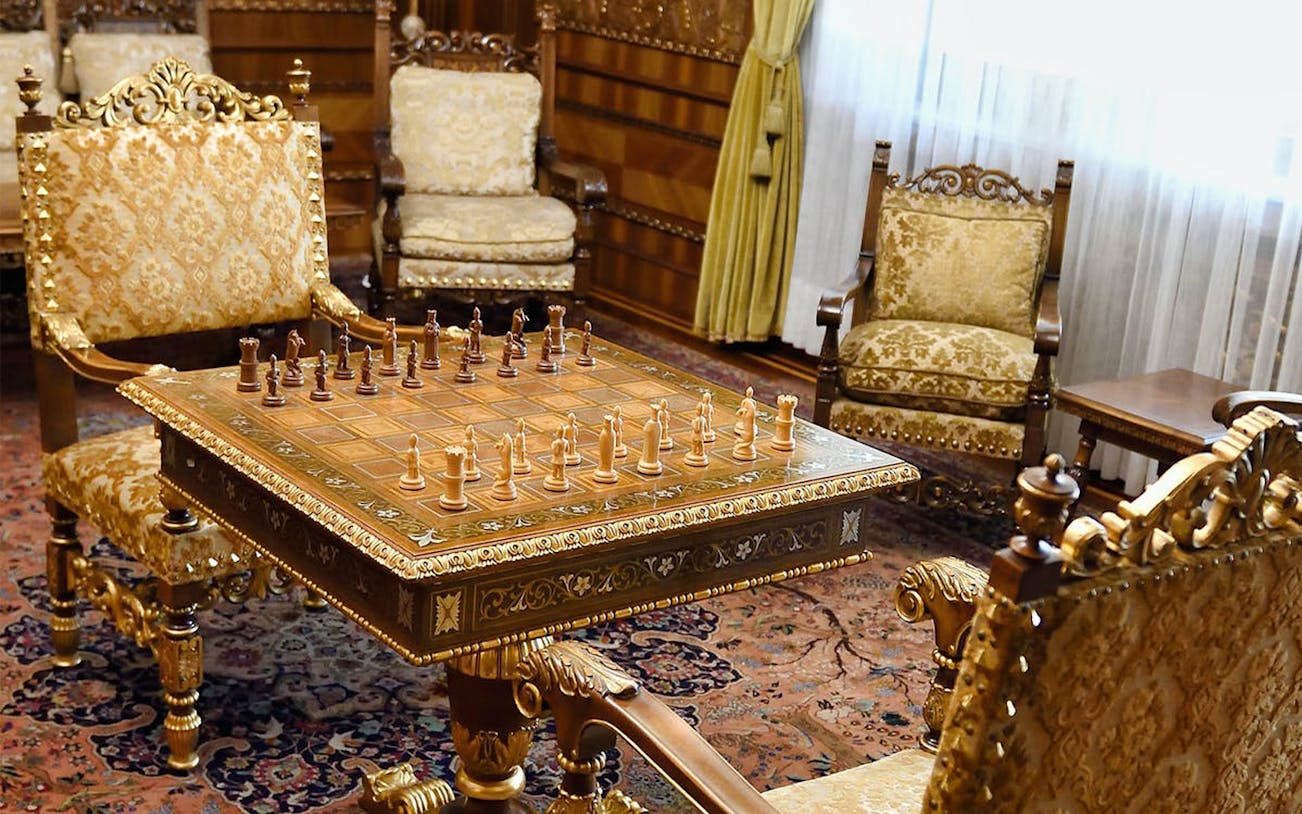 Chess set on ornate table in Ceausescu Mansion's opulent room, part of Fast Track Guided Tour.