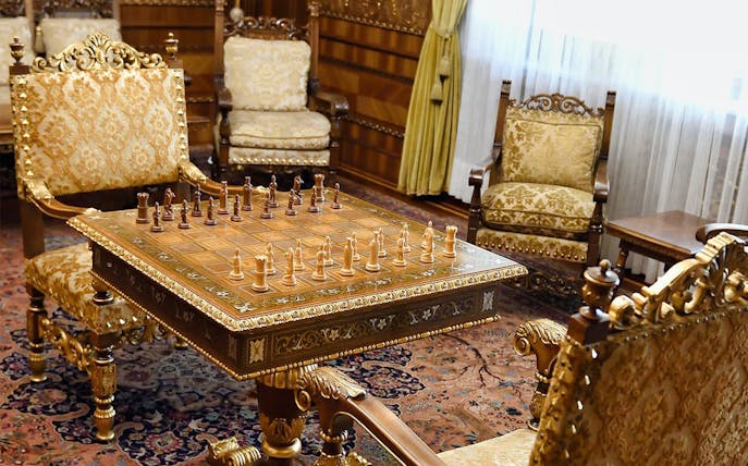 Chess set on ornate table in Ceausescu Mansion's opulent room, part of Fast Track Guided Tour.