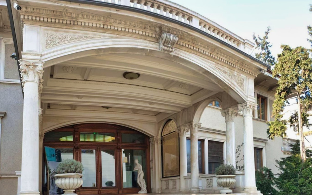 Entrance of Ceausescu Mansion with ornate columns and archway, Bucharest.