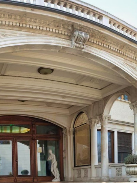 Entrance of Ceausescu Mansion with ornate columns and archway, Bucharest.