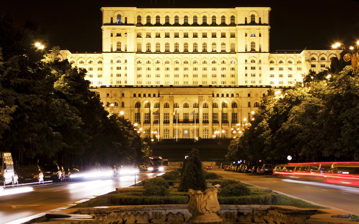 Parliament Palace illuminated at night during Communist City Tour, Bucharest.