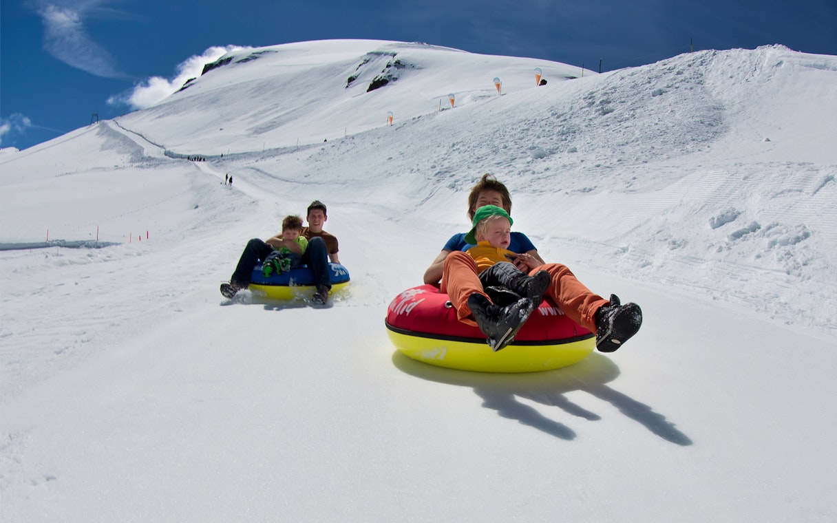 Snow tubing on Mount Titlis, Lucerne, with families enjoying the snowy slopes.