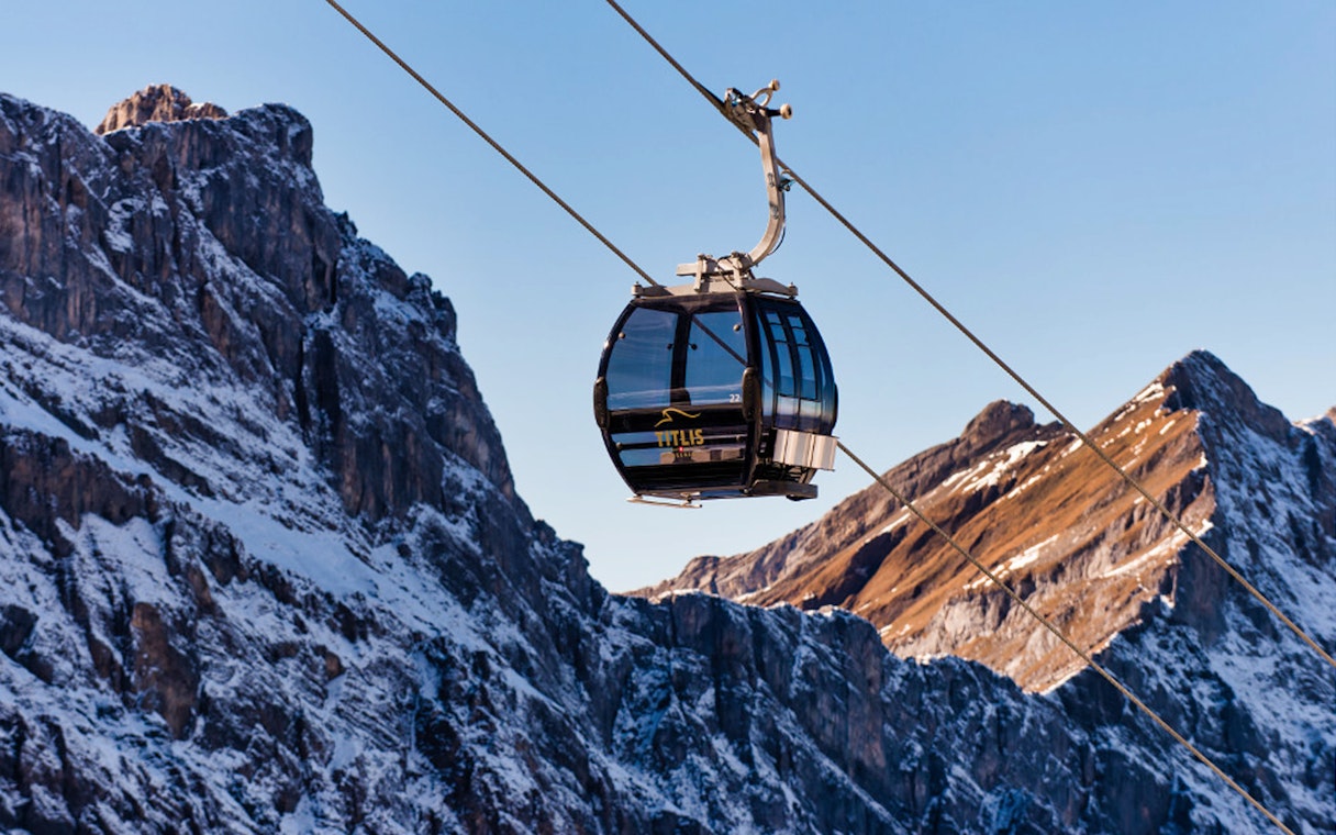 Cable car ascending Mount Titlis with snowy peaks in Lucerne, Switzerland.