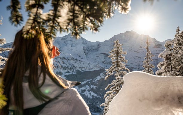 Person enjoying snowy mountain view during guided sledding in Sulwald, near Interlaken.