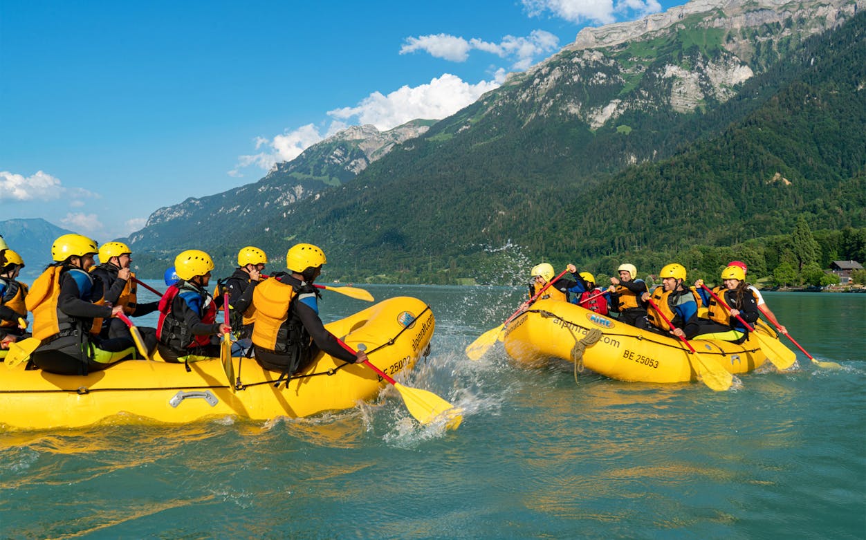 River rafting on turquoise waters in Bern with scenic mountain backdrop.