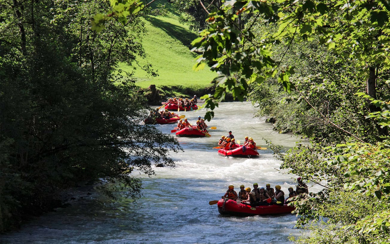 Rafting on a river in Thun, Switzerland, surrounded by lush greenery.
