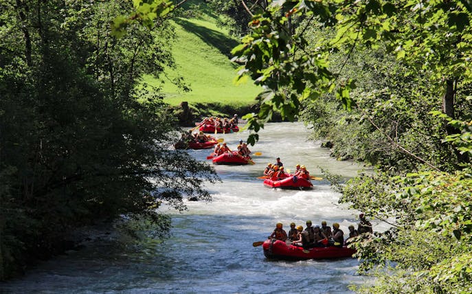 Rafting on a river in Thun, Switzerland, surrounded by lush greenery.