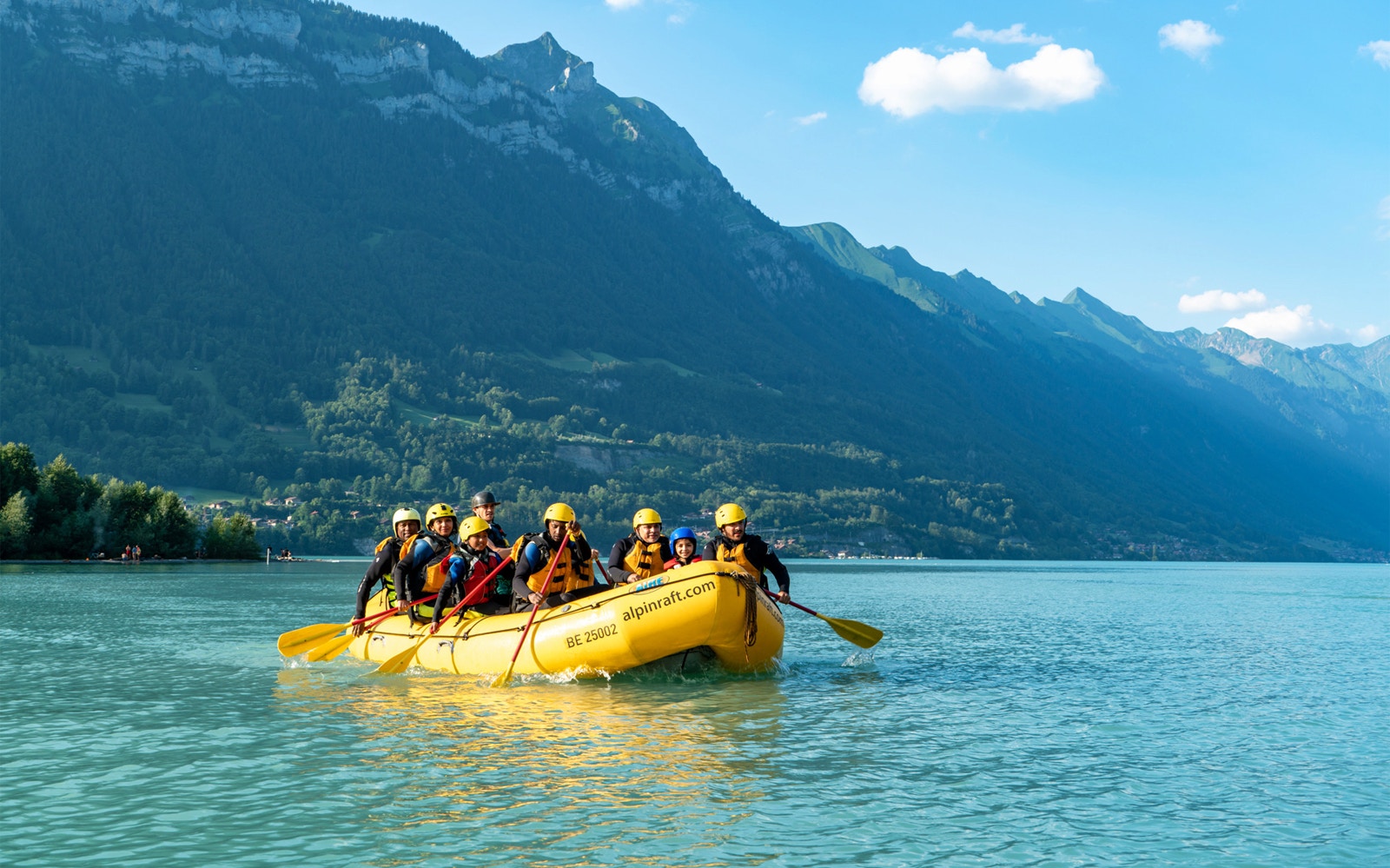 River rafting on Lütschine River, Interlaken with guide and group enjoying drinks.