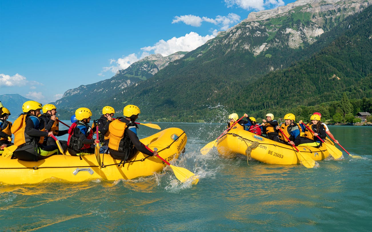 River rafting on Simme River with groups in yellow rafts, surrounded by mountains.