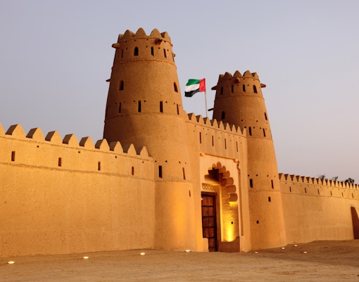 Al Ain oasis with palm trees and traditional architecture on Al Ain City Tour from Dubai.