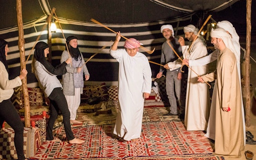 Participants engaging in traditional Bedouin dance during Premium Bedouin Culture Safari in UAE.
