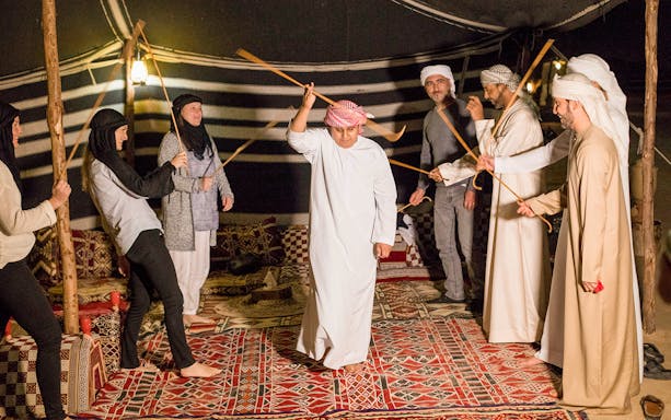 Participants engaging in traditional Bedouin dance during Premium Bedouin Culture Safari in UAE.