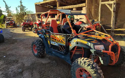 Quad bikes parked at a desert adventure site, part of a Camel Riding, Quad Biking & Spa Rejuvenation tour.