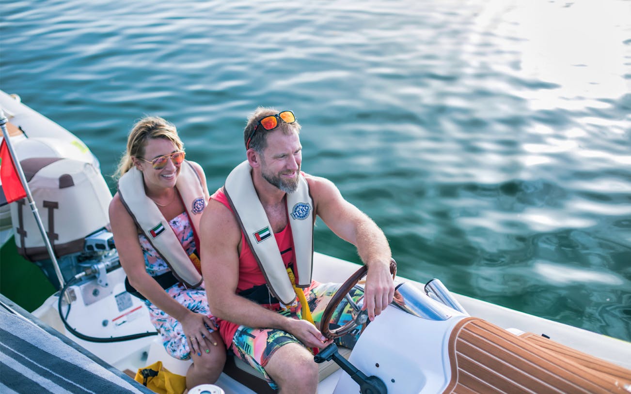 Couple enjoying Hero Signature self-drive boat tour on open water.