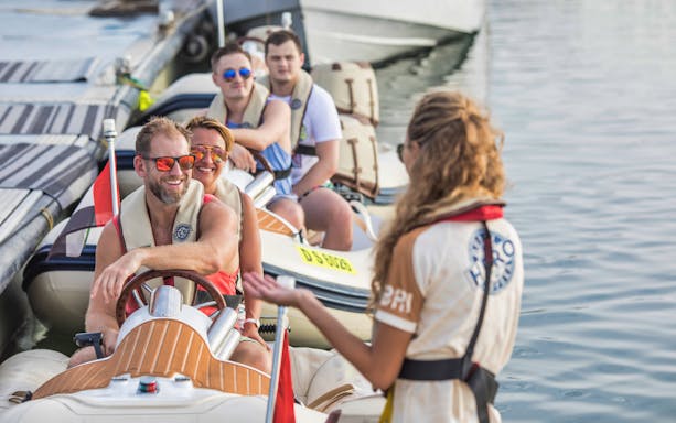 Self-drive boat tour participants receiving instructions on the water.
