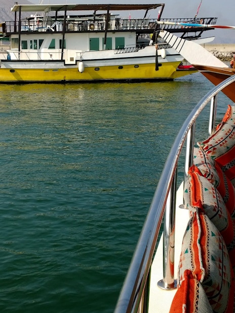 Dhow boat with colorful seating on Musandam Dibba tour, Oman.