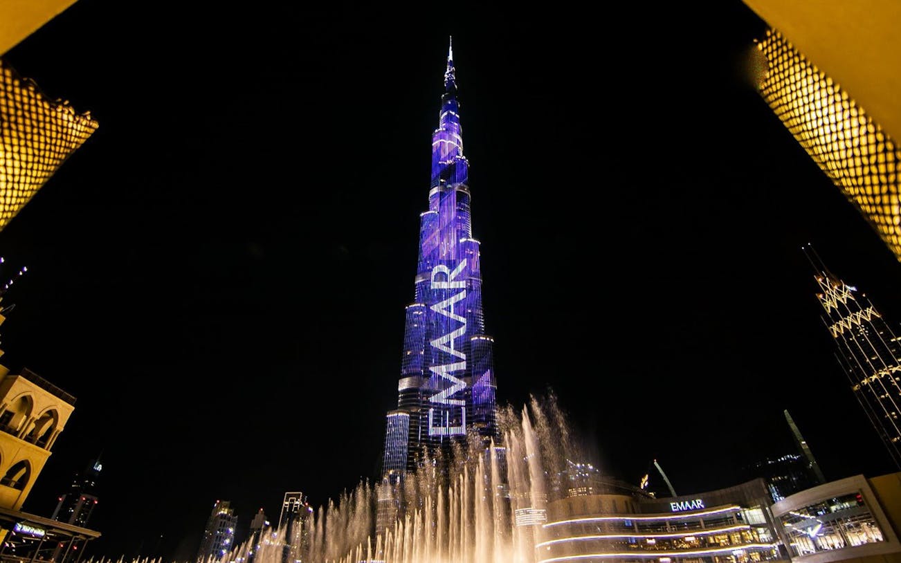 Burj Khalifa illuminated at night with fountain show in Dubai.