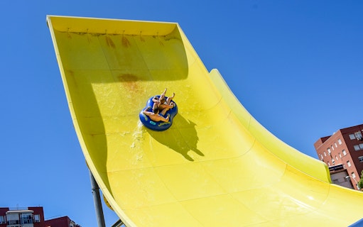 Visitors on a yellow water slide at Guadalpark Sevilla.
