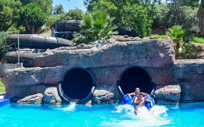 Visitors exiting water slide at Guadalpark Sevilla.