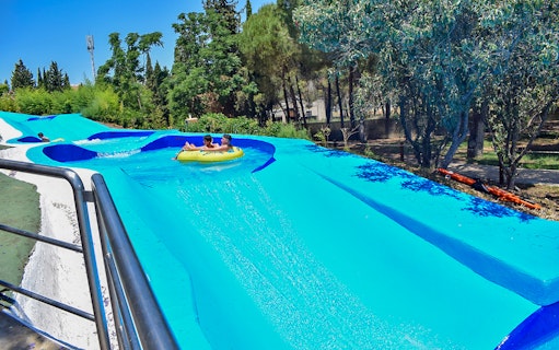 Visitors enjoying a water slide at Guadalpark Sevilla.