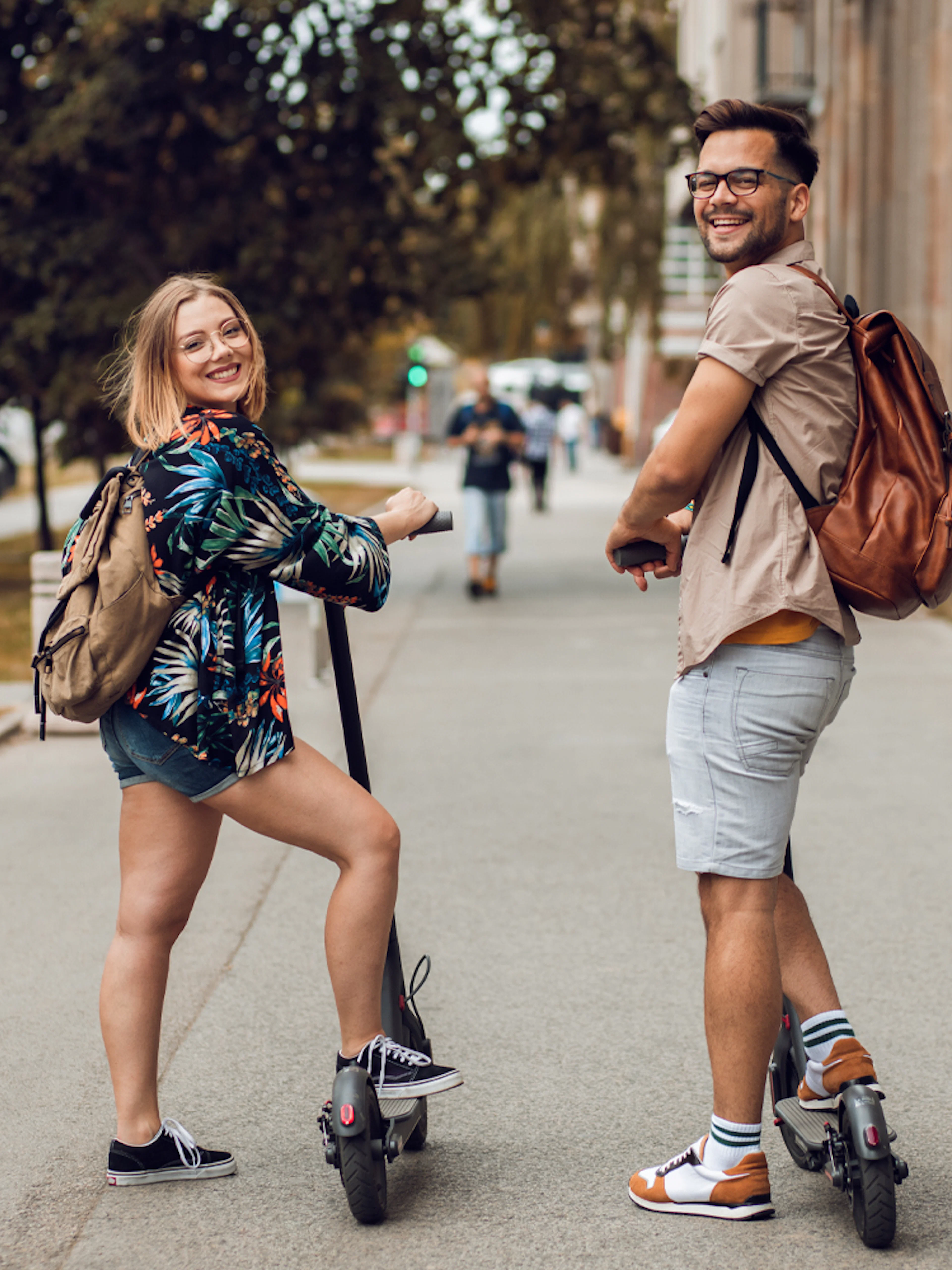 Two people on e-scooters during a city sightseeing tour.