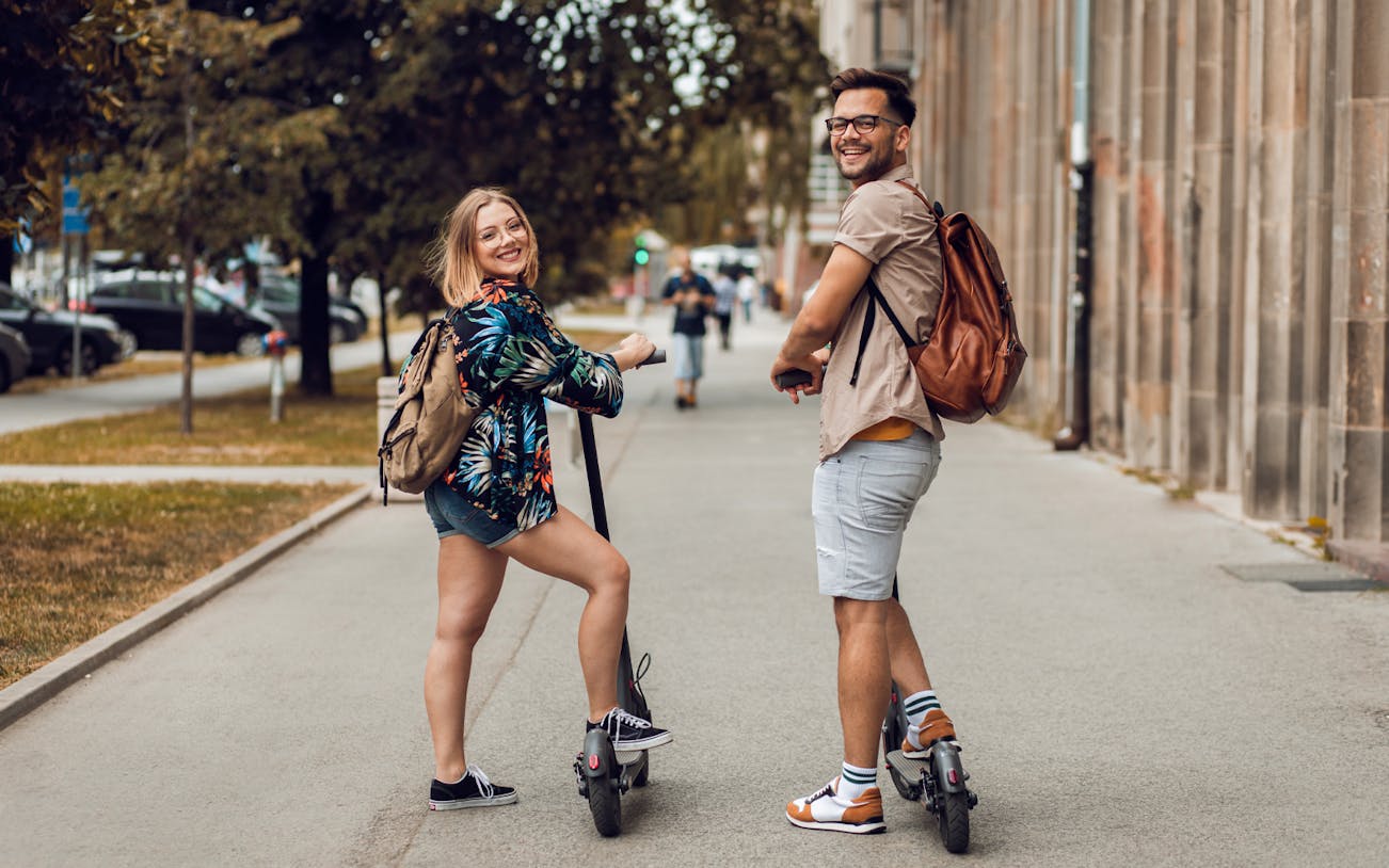 Two people on e-scooters during a city sightseeing tour.