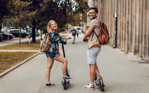 Two people on e-scooters during a city sightseeing tour.