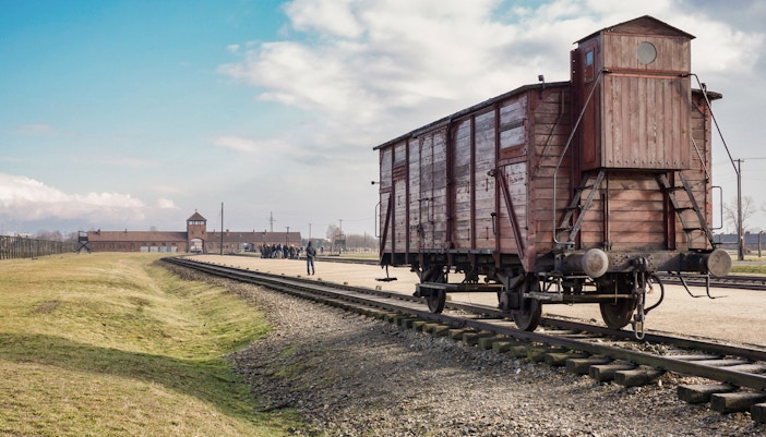 Auschwitz Birkenau entrance with tour group and guide, Krakow small group guided tour.