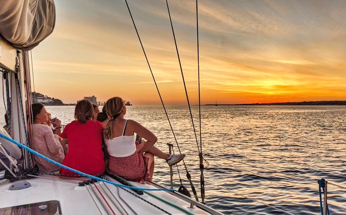 Group enjoying a sunset on a private cruise in Lisbon.