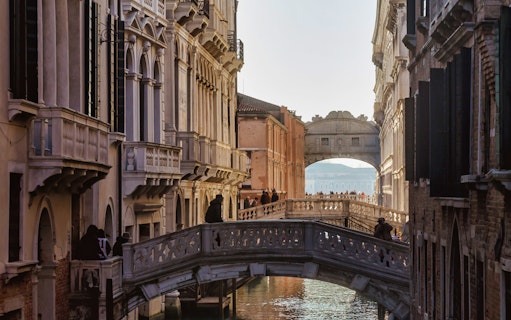Venice canal view with the Bridge of Sighs in the background, part of a self-guided tour.