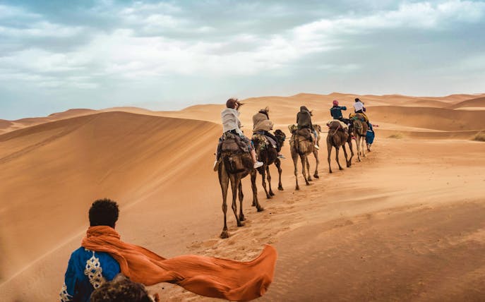 Camel caravan traversing Agafay Desert dunes on a private tour with lunch.