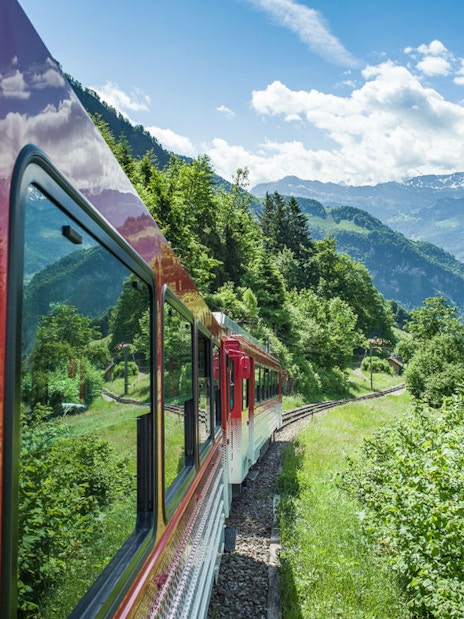 Train ascending Mount Rigi with scenic views of Swiss Alps and Lake Lucerne.