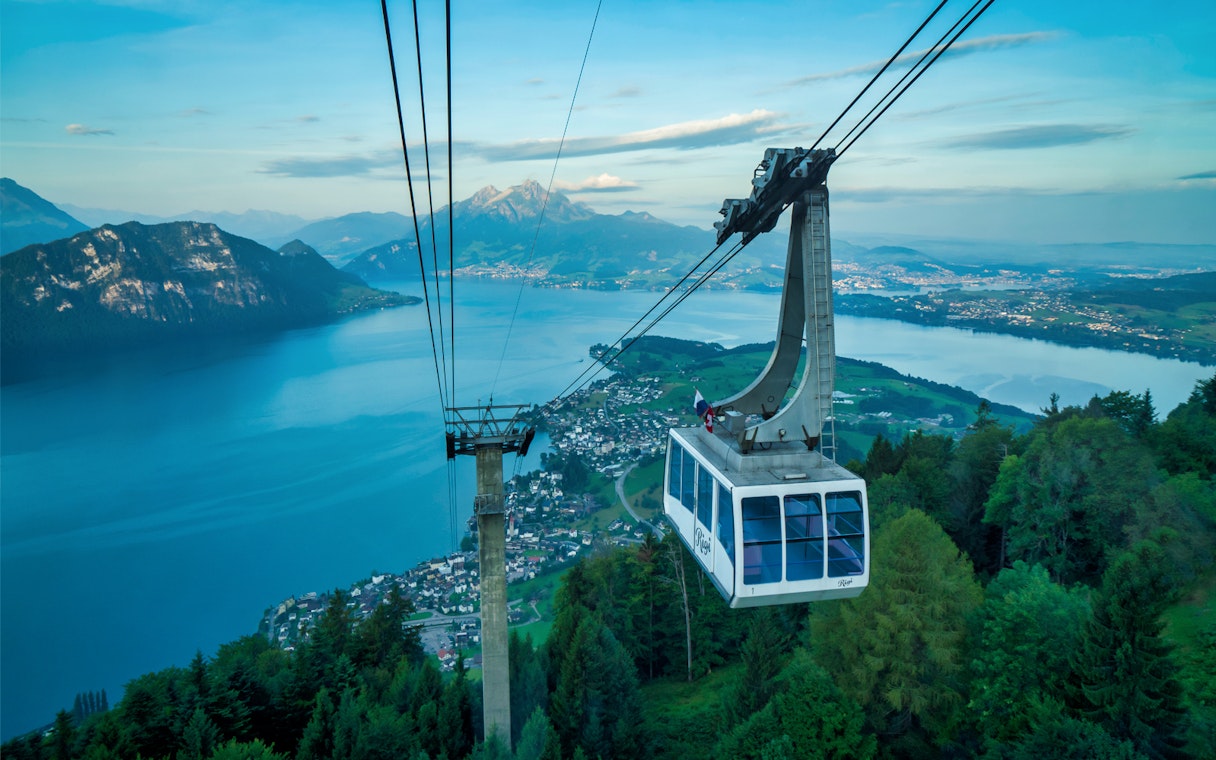 Cable car ascending Mount Rigi with view of Lake Lucerne and surrounding mountains.