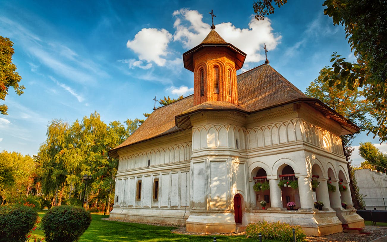 Snagov Monastery exterior with lush greenery, part of Half-Day Trip to Snagov & Mogosoaia.