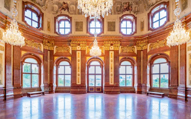 Belvedere Palace interior with ornate chandeliers and large windows, Vienna.