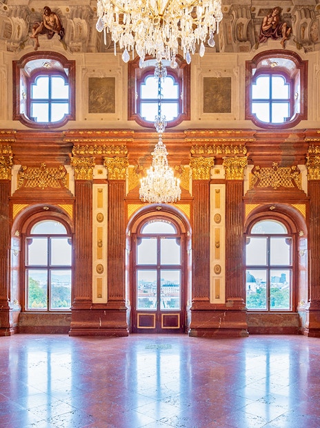 Belvedere Palace interior with ornate chandeliers and large windows, Vienna.
