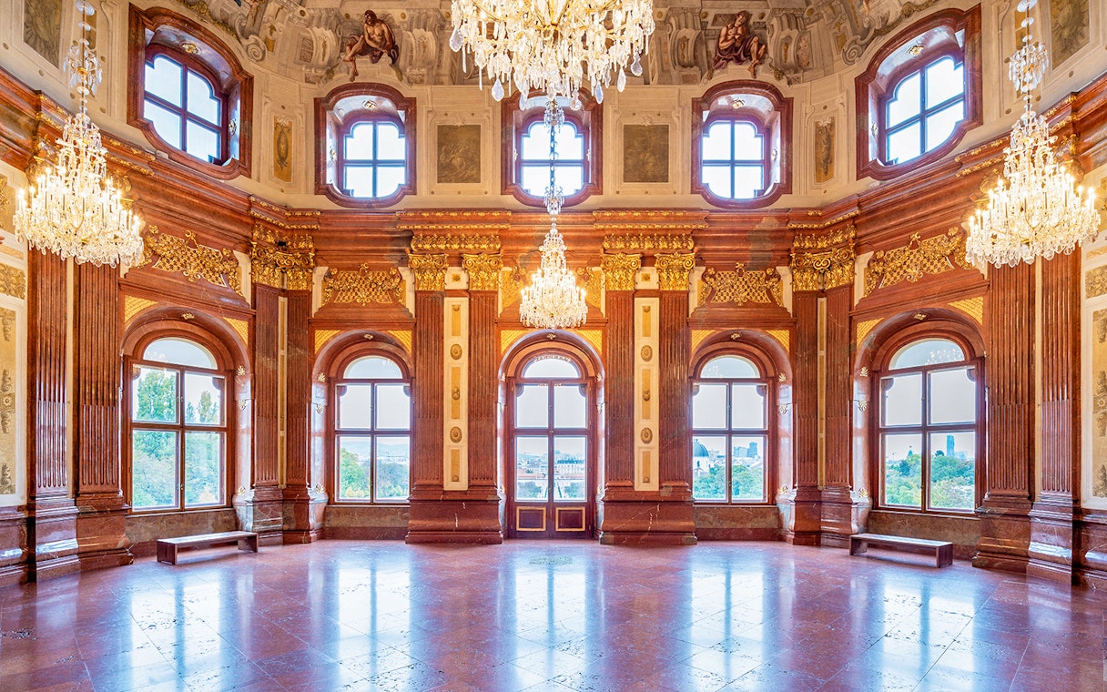 Belvedere Palace interior with ornate chandeliers and large windows, Vienna.