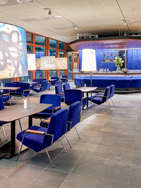 Contemporary art-themed café interior at Belvedere 21, Vienna, with blue seating and artistic lamps.