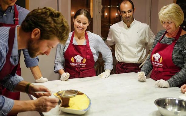 Participants in a pasta and tiramisu class in Rome, learning dessert preparation.