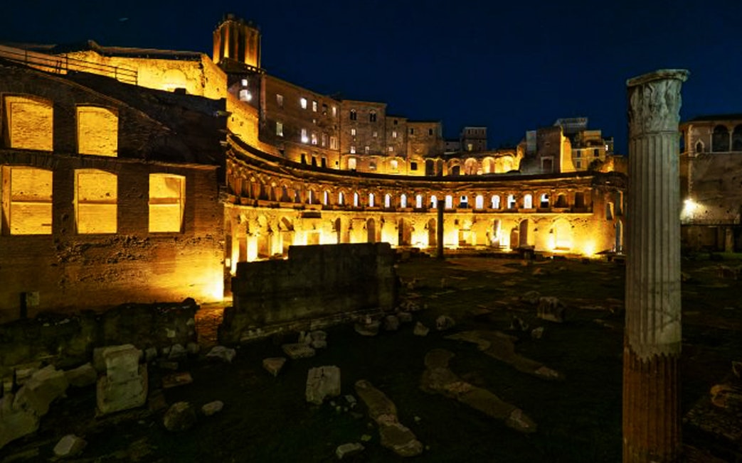 Ancient ruins illuminated at night in Rome, Italy.