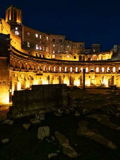 Ancient ruins illuminated at night in Rome, Italy.