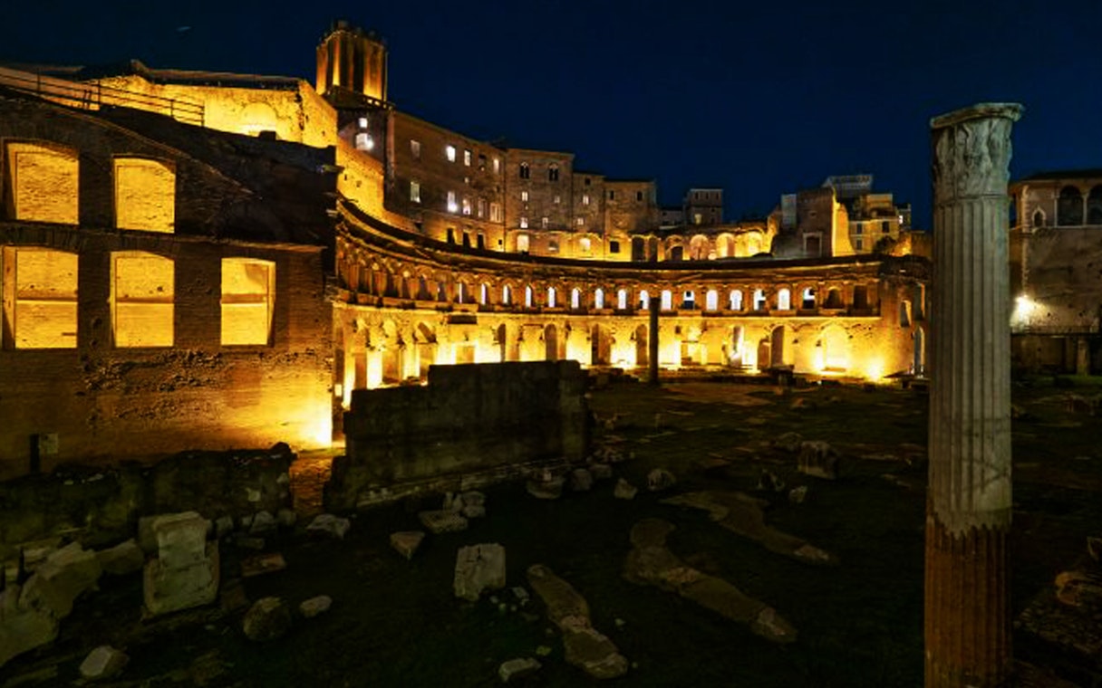 Ancient ruins illuminated at night in Rome, Italy.