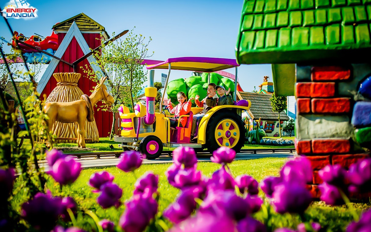 Children riding a colorful tractor ride at Energylandia Amusement Park.