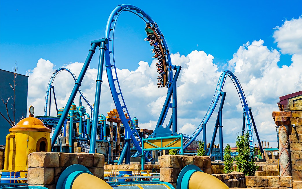 Roller coaster loop at Energylandia Amusement Park under a blue sky.