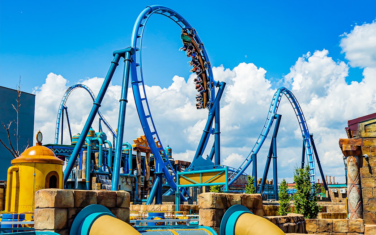Roller coaster loop at Energylandia Amusement Park under a blue sky.