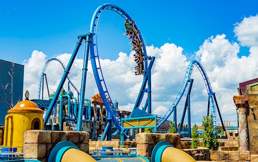 Roller coaster loop at Energylandia Amusement Park under a blue sky.
