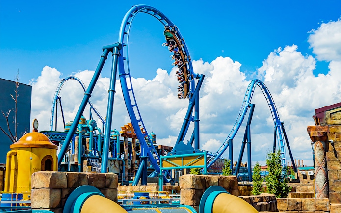 Roller coaster loop at Energylandia Amusement Park under a blue sky.