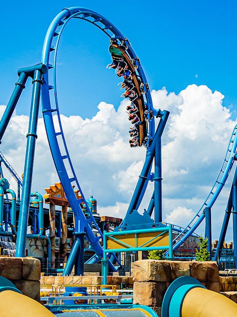 Roller coaster loop at Energylandia Amusement Park under a blue sky.